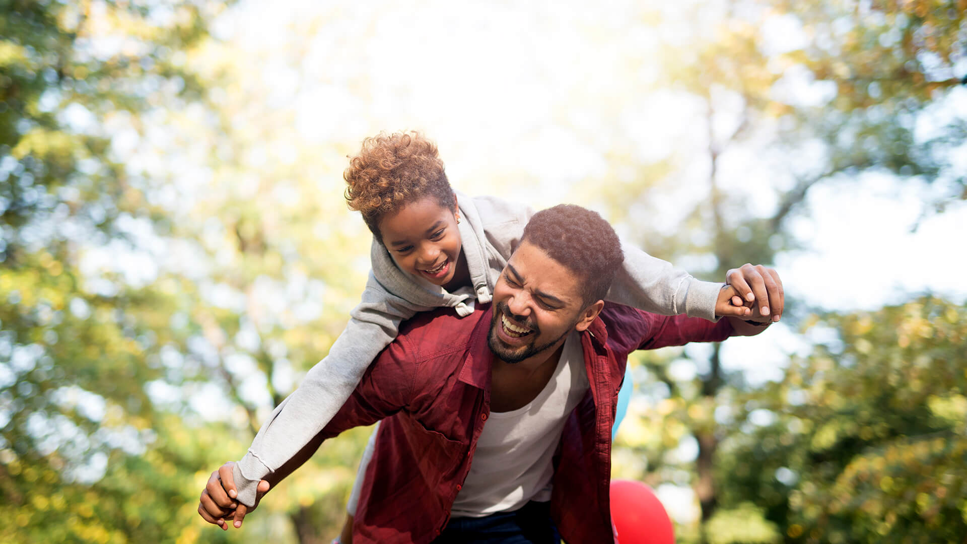 father-holding-his-daughter-on-shoulders-and-laughing